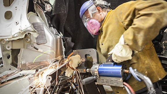 Toyota Collision Center Technician buffing out vehicle body panel.